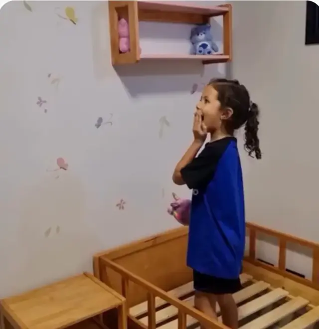 Menina surpresa olhando o mural de borboletas no quarto